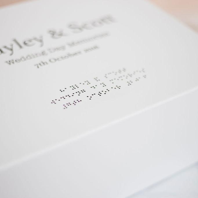 A close up of the braille which reads Hayley & Scott, Wedding Day Memories, 7th October 2016.