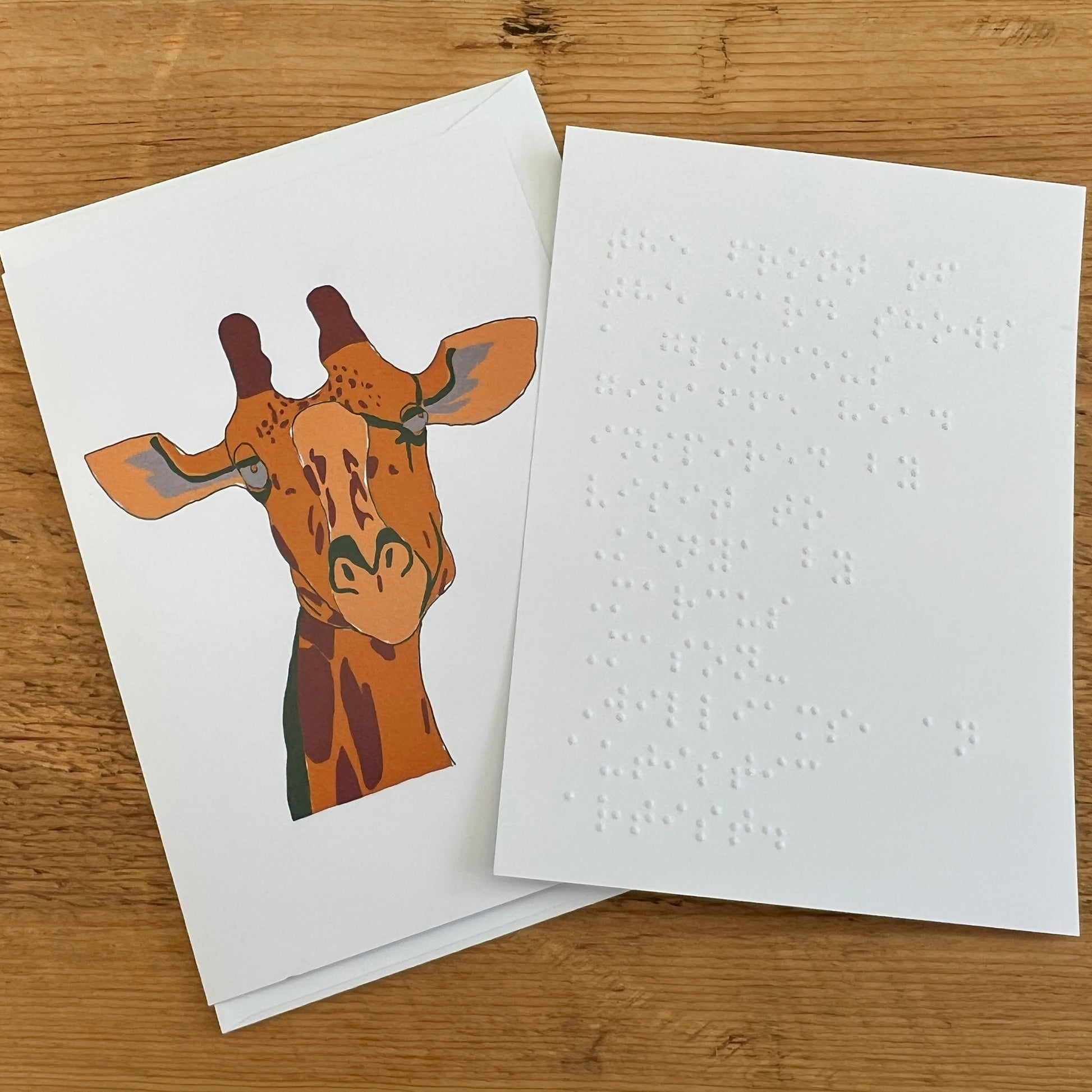 Greetings card featuring a giraffe illustration with a separate white insert embossed with Braille