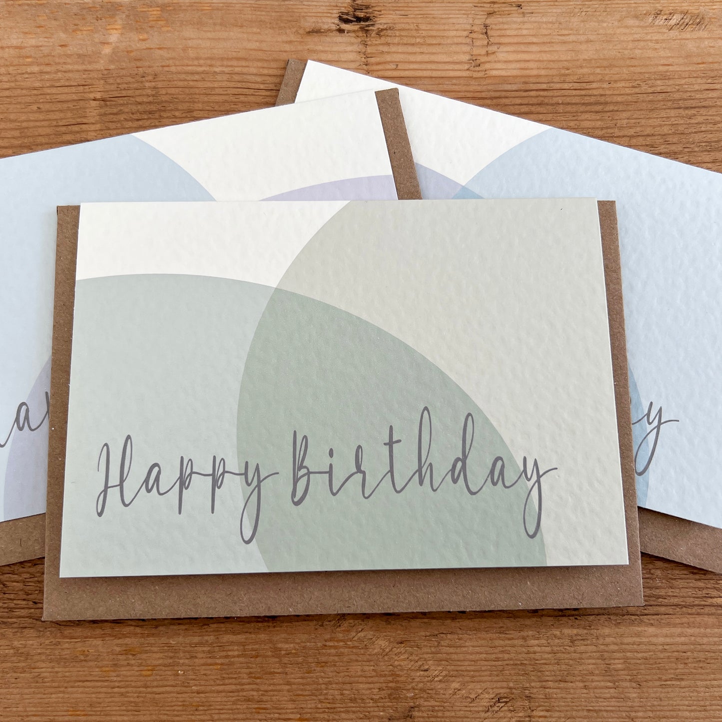 Set of pastel birthday cards with 'Happy Birthday' in script and Braille underneath each.