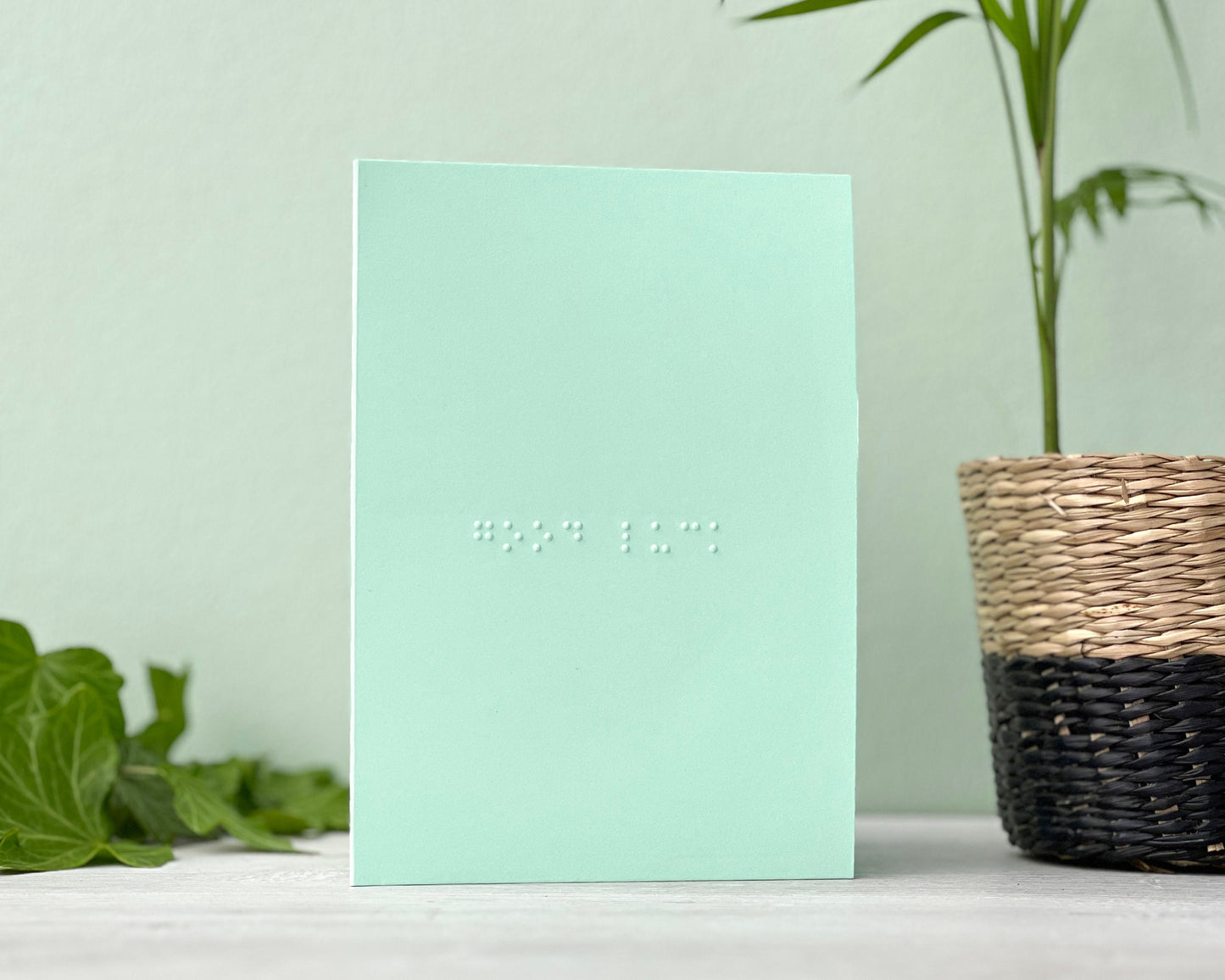 A portrait pastel green card with good luck written in grade 1 braille.