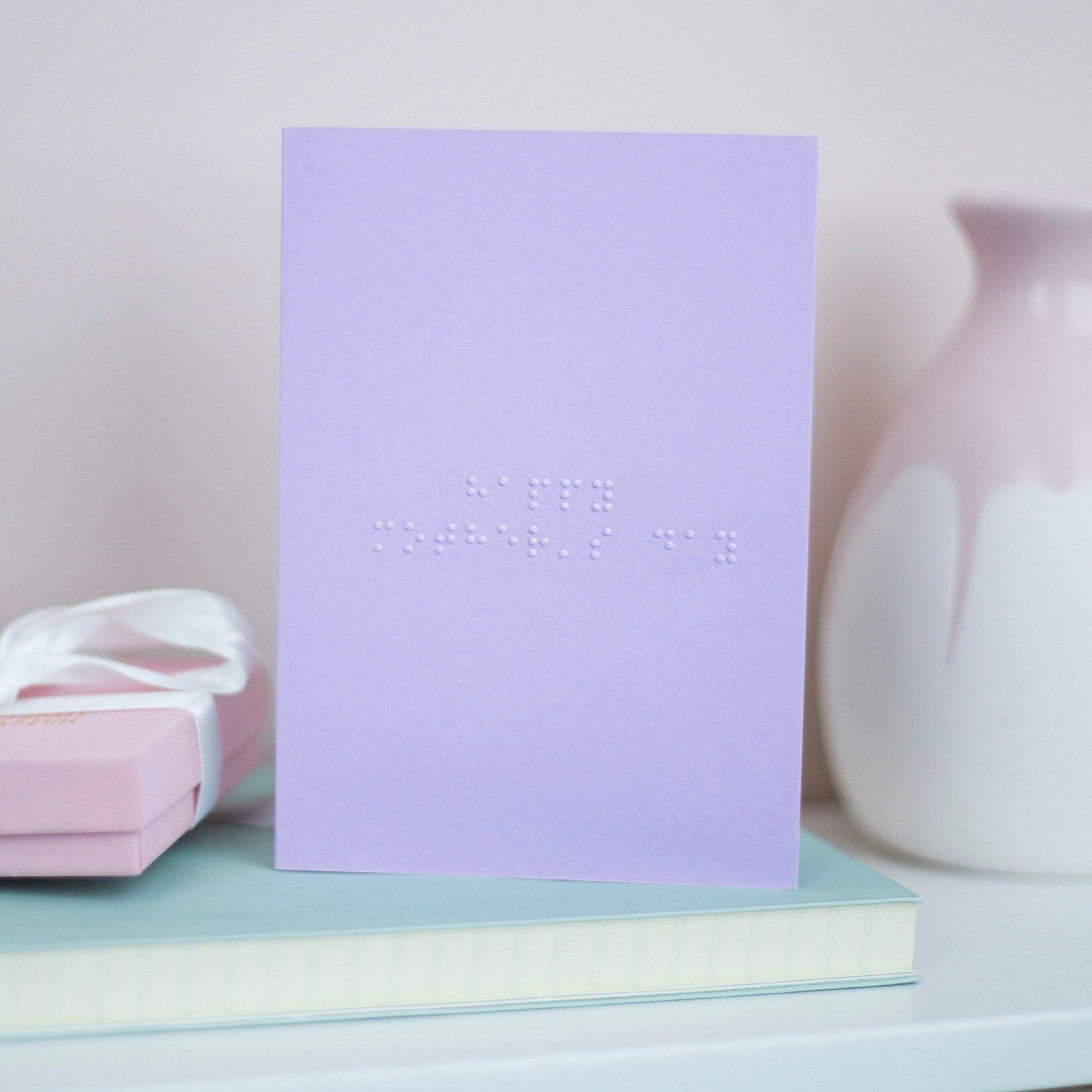 A pastel purple card with Happy Mother's Day written in lower case braille.
