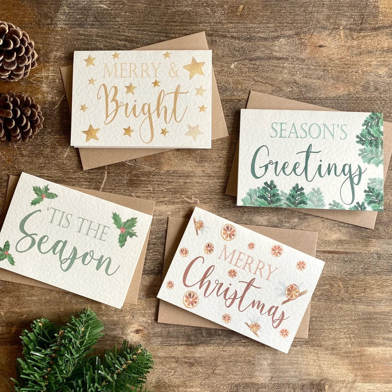 A pack of four Christmas cards, each is A6 and made from textured card. They say, Merry & Bright, Season's Greetings, 'Tis the Season and Merry Christmas.