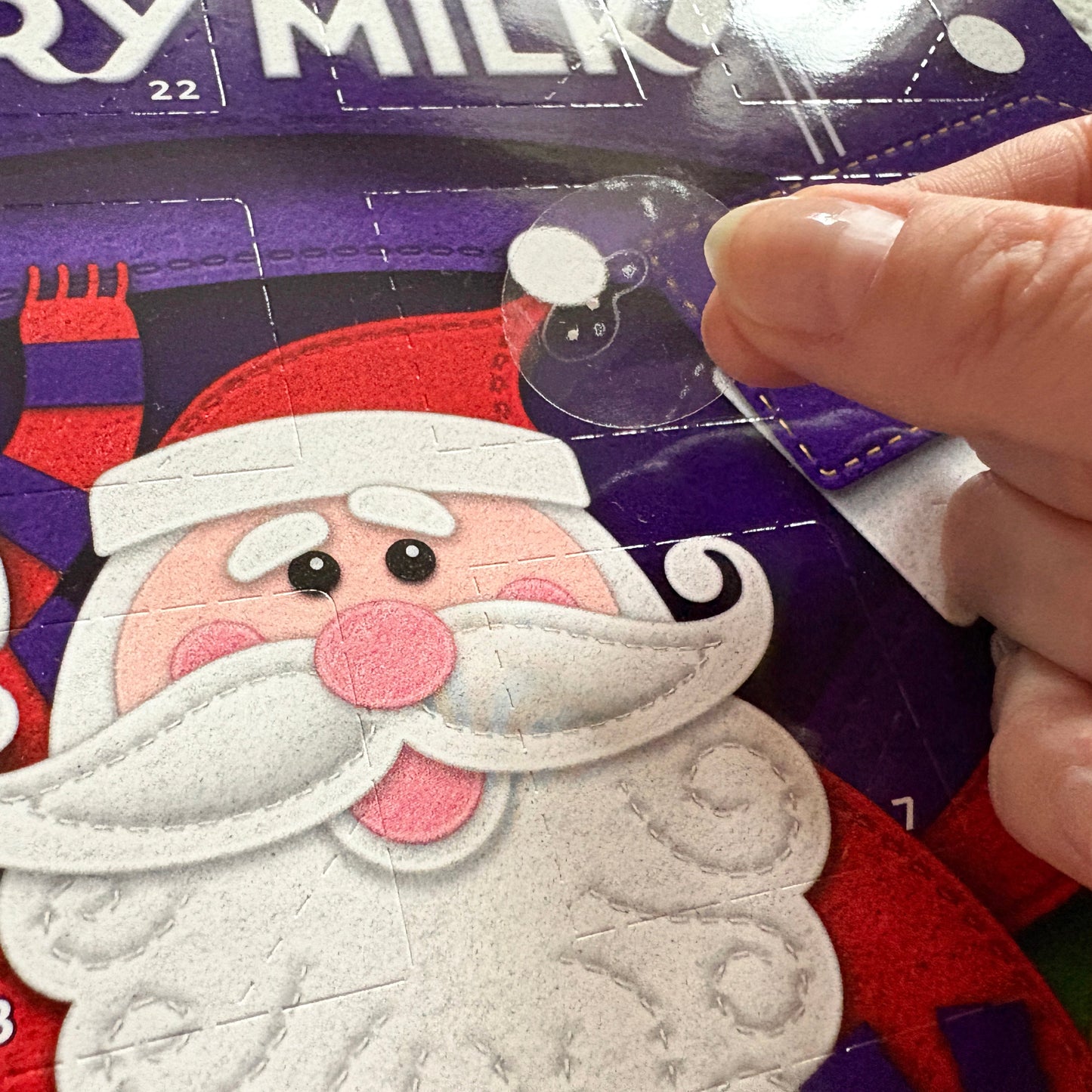 A braille sticker being adding to an advent calendar.