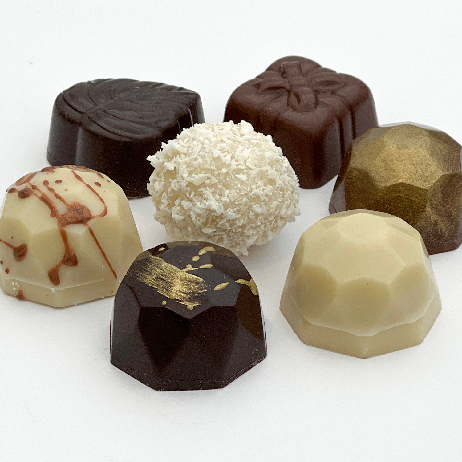 Seven luxury handcrafted chocolates, a mix of white, dark and milk chocolate. 