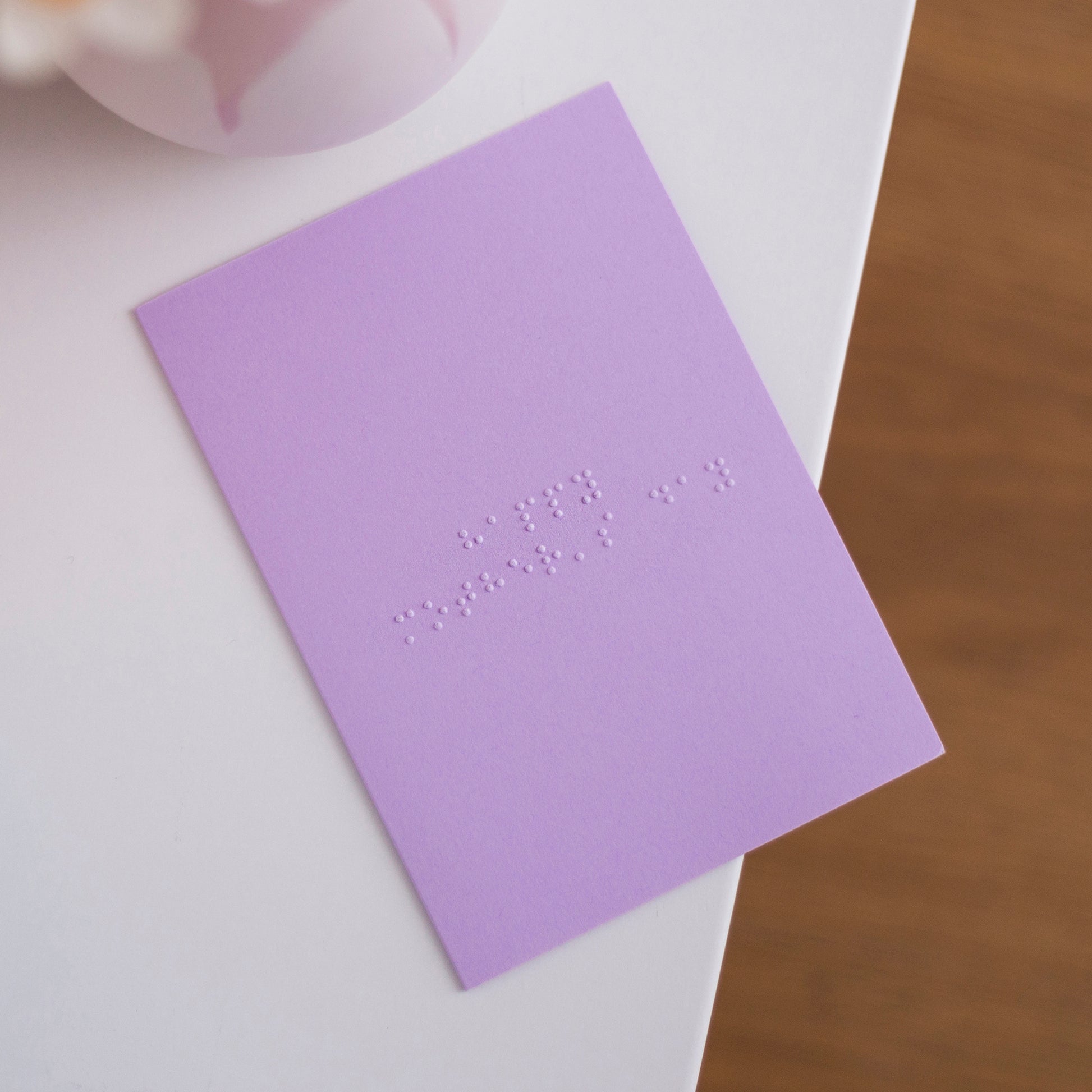 A pastel purple card with Happy Mother's Day written in lower case braille. 