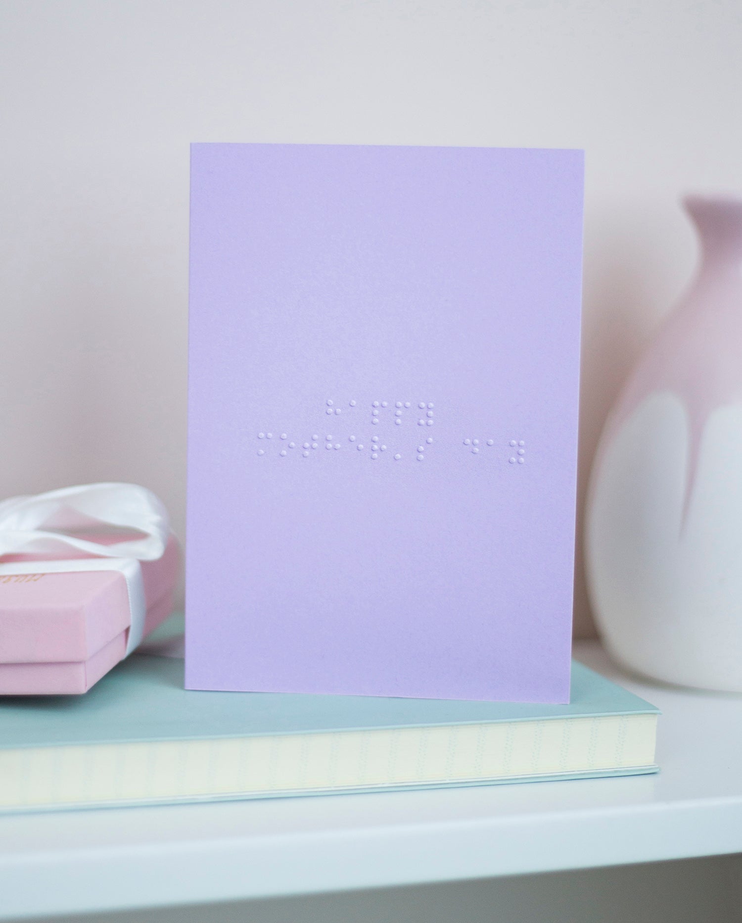 A pastel purple card with Happy Mother's Day written in lower case braille. 