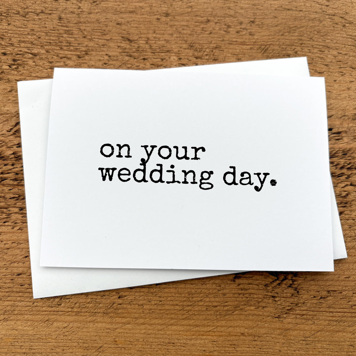 A white A6 card with text that reads: on your wedding day written in black typewriter style font.