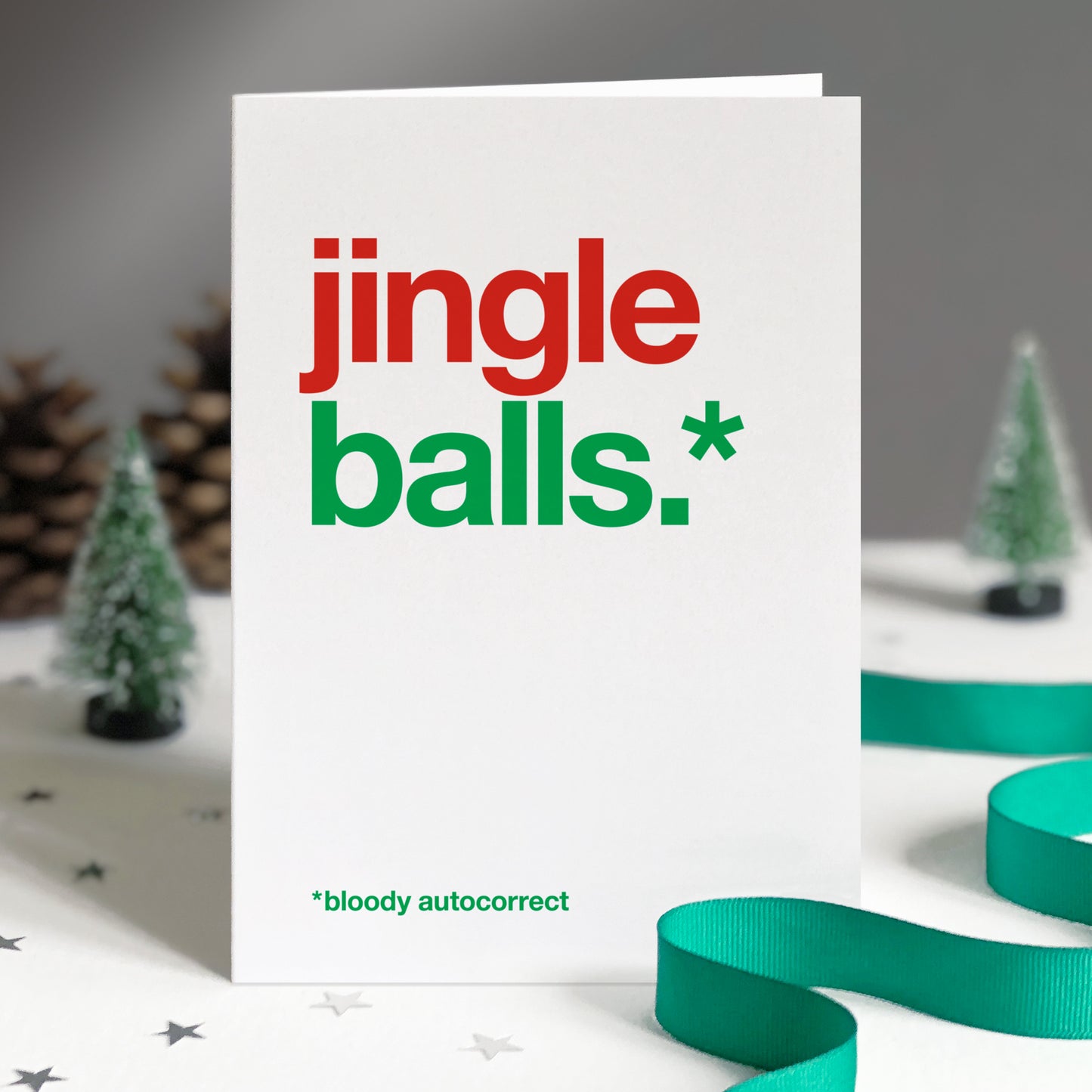 A white card with colourful text saying jingle balls.* *bloody autocorrect