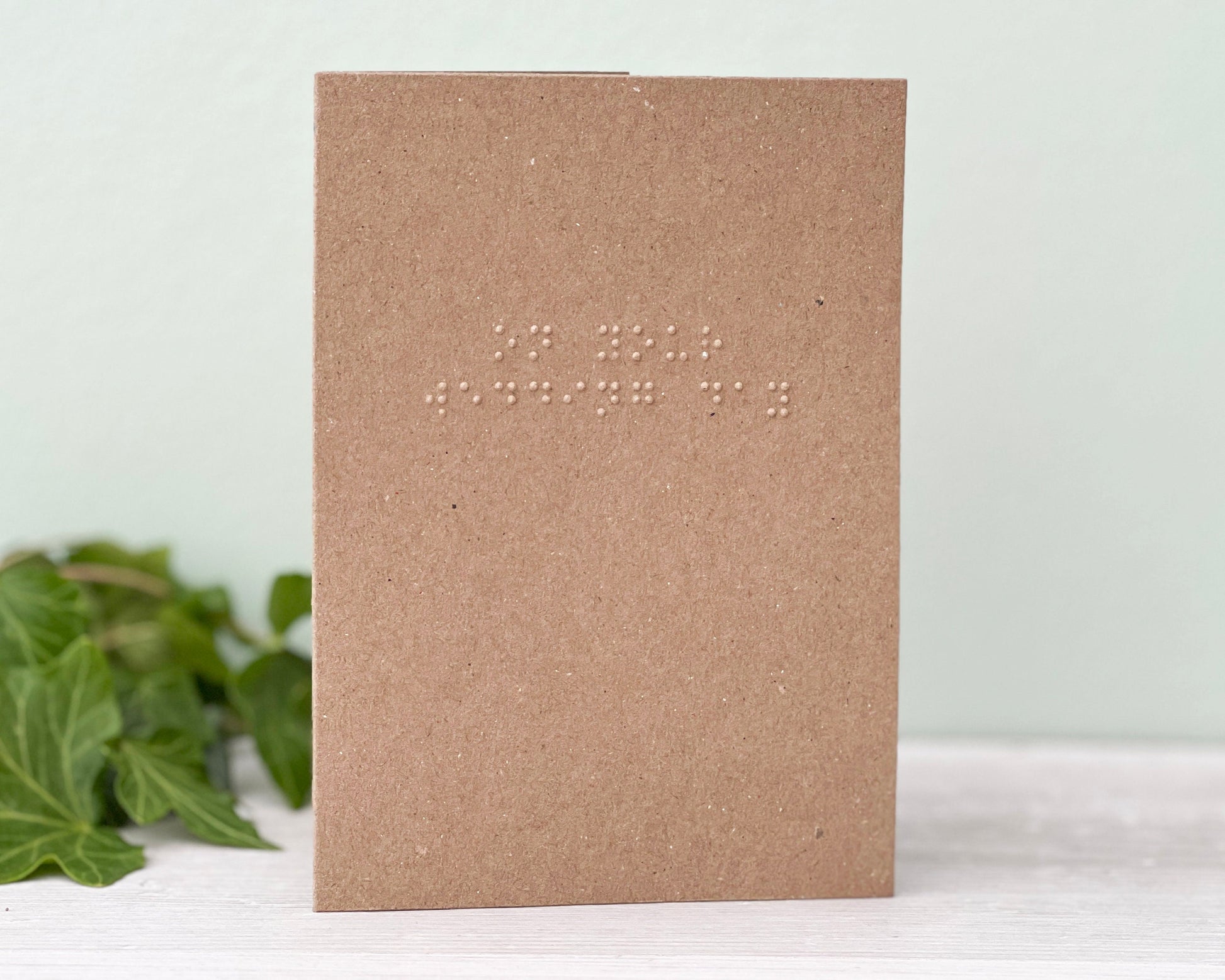A kraft brown portrait card with on your wedding day written in grade 1, lower case UEB braille.