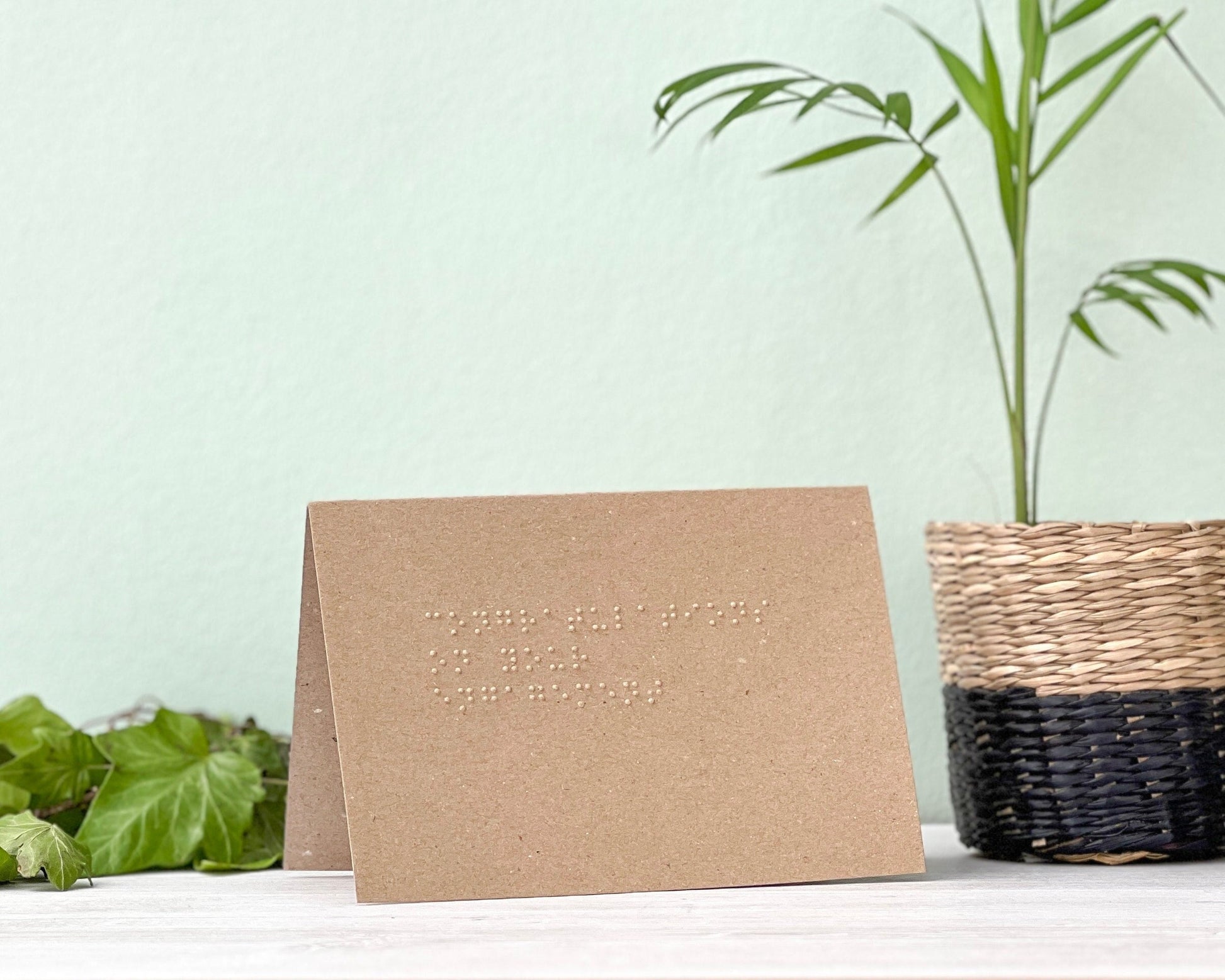 A kraft brown landscape greetings card with congratulations on your engagement written in grade 1 braille.