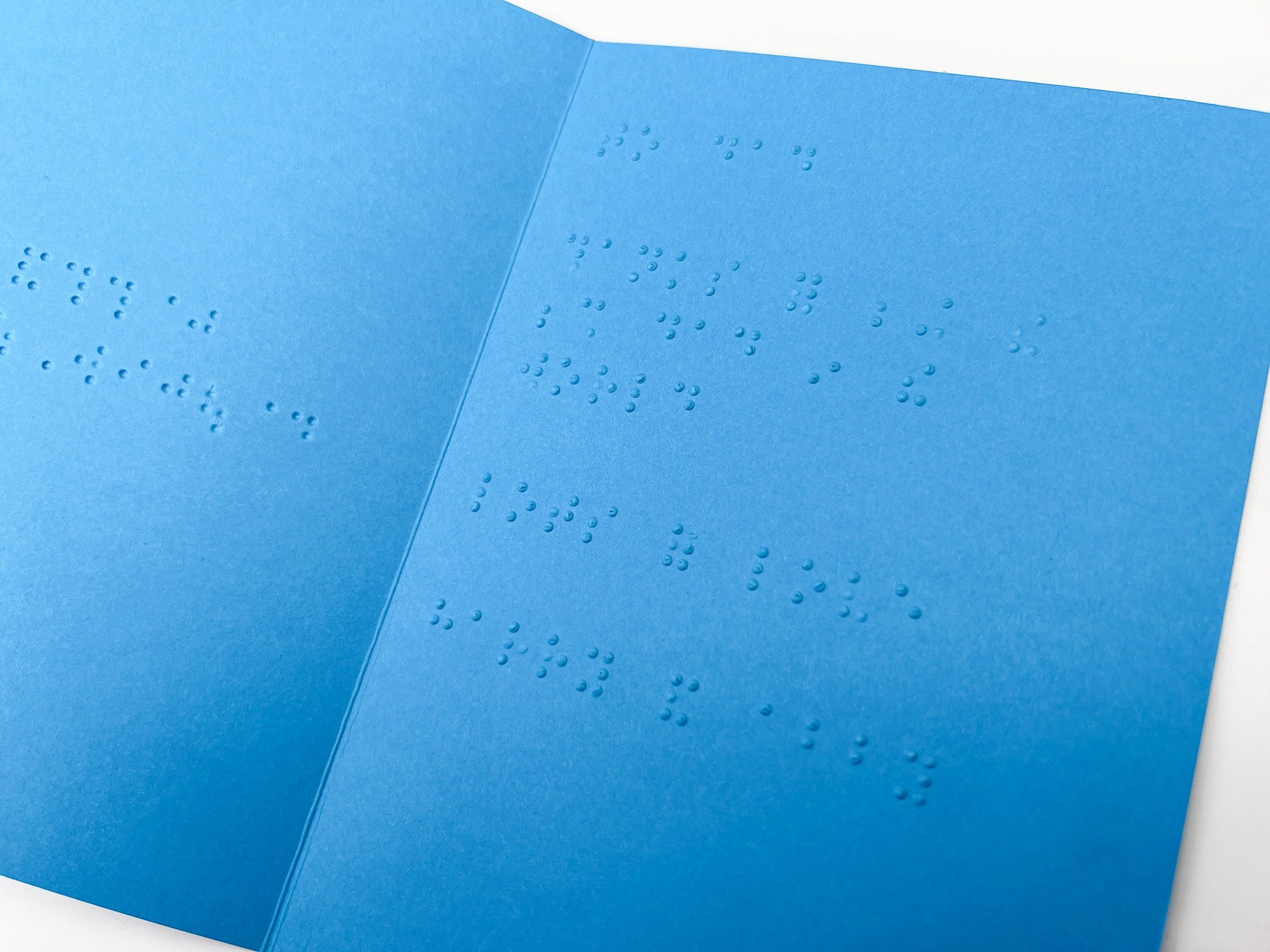 Image shows an open blue Father&#39;s Day card with text inside that reads to dad, thanks for being the best dad in the world, lots of love harry and abby, in lower case grade 2 UEB braille.