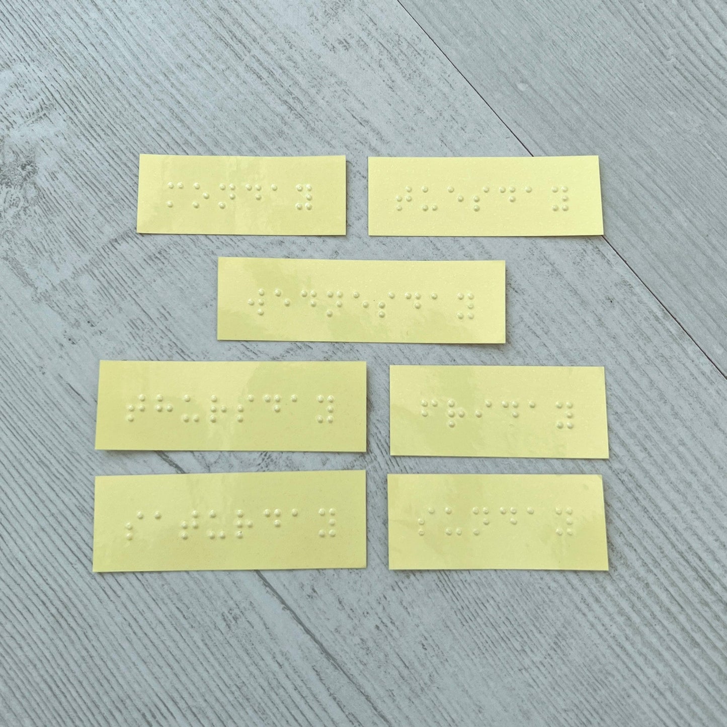 Seven braille labels with the days of the week on.
